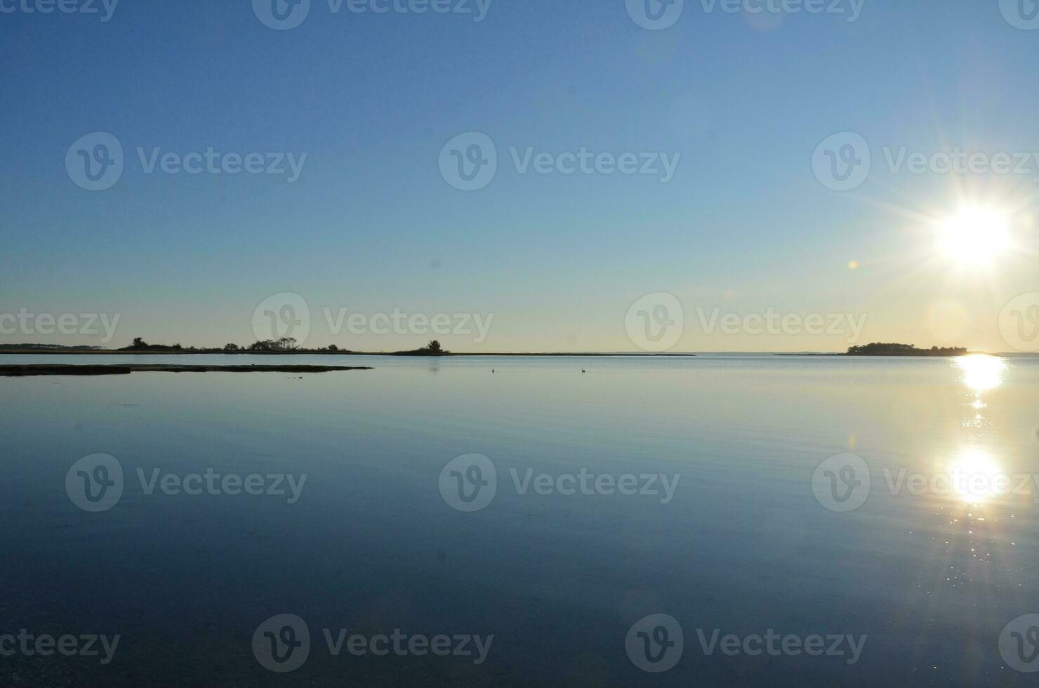 en sjö eller flod med brun gräs och Strand foto