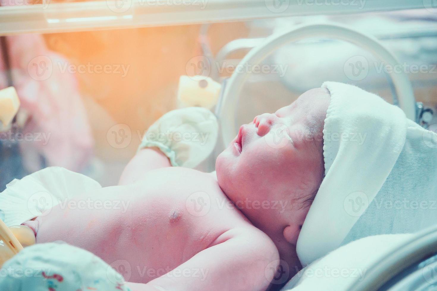 nyfödd bebis inuti inkubator i sjukhus posta leverans rum foto