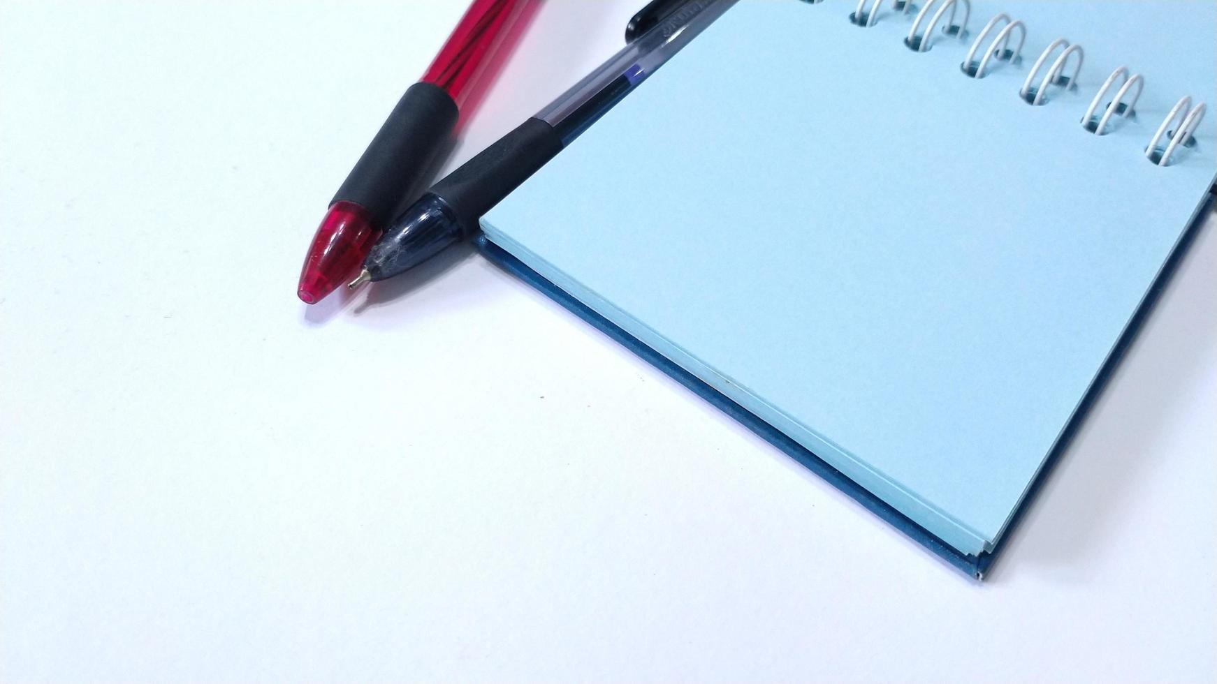 tom anteckningsbok med penna på enkel bakgrund foto