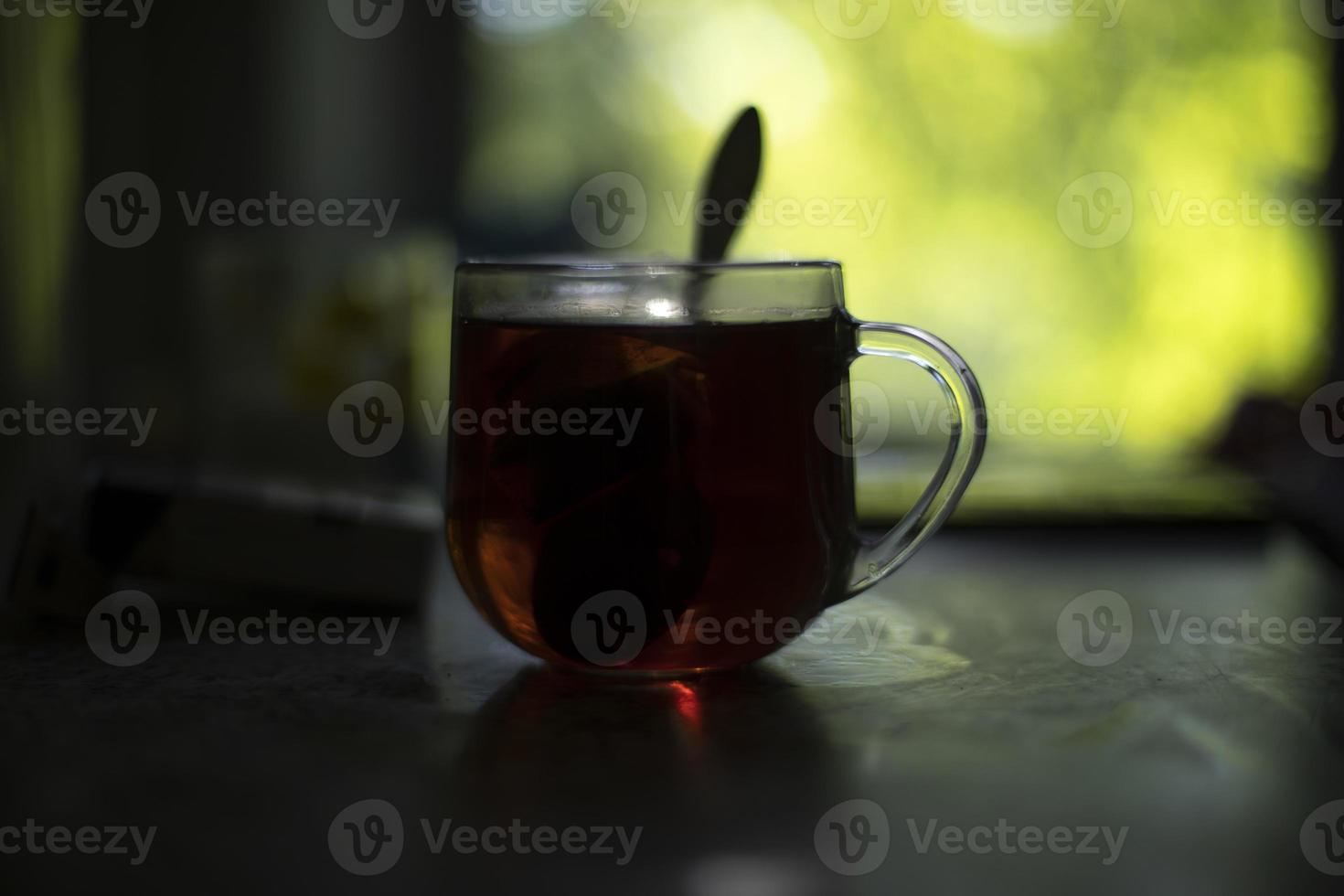 te i glas. te i morgon. transparent kopp på tabell. frukost på gryning. foto