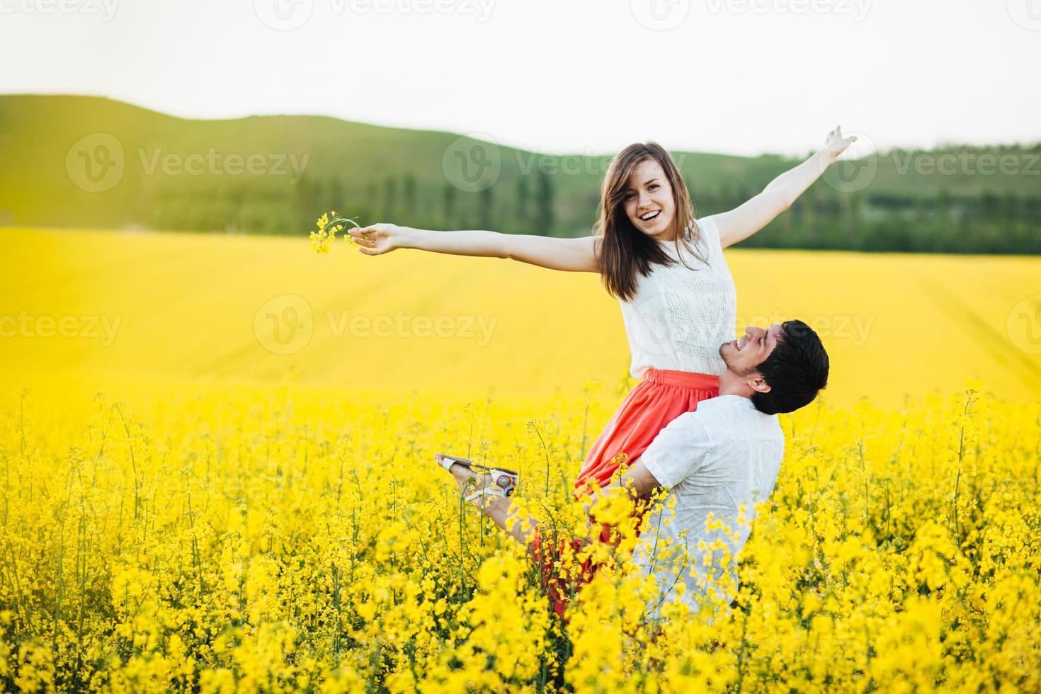 porträtt av lyckliga unga familjepar känner lycka och frihet, poserar tillsammans på gul äng mot blå himmel, visar positivitet och sann relation. romantiska ungdomar utomhus foto