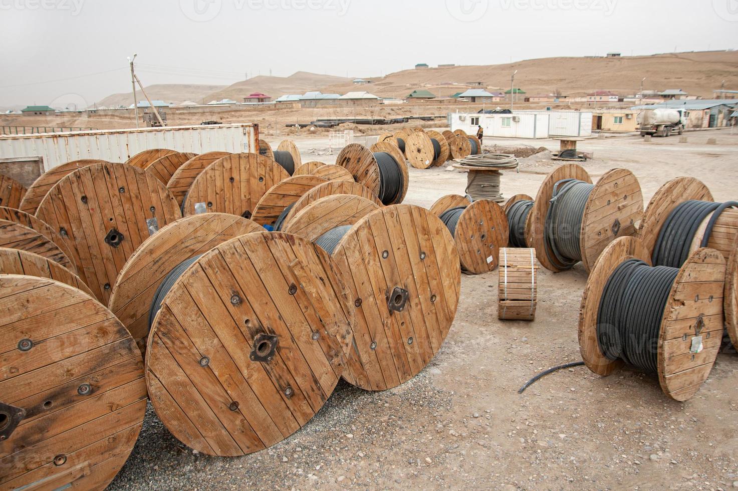 en närbild av stor industriell trä- bobiner med kabel- på en konstruktion webbplats foto