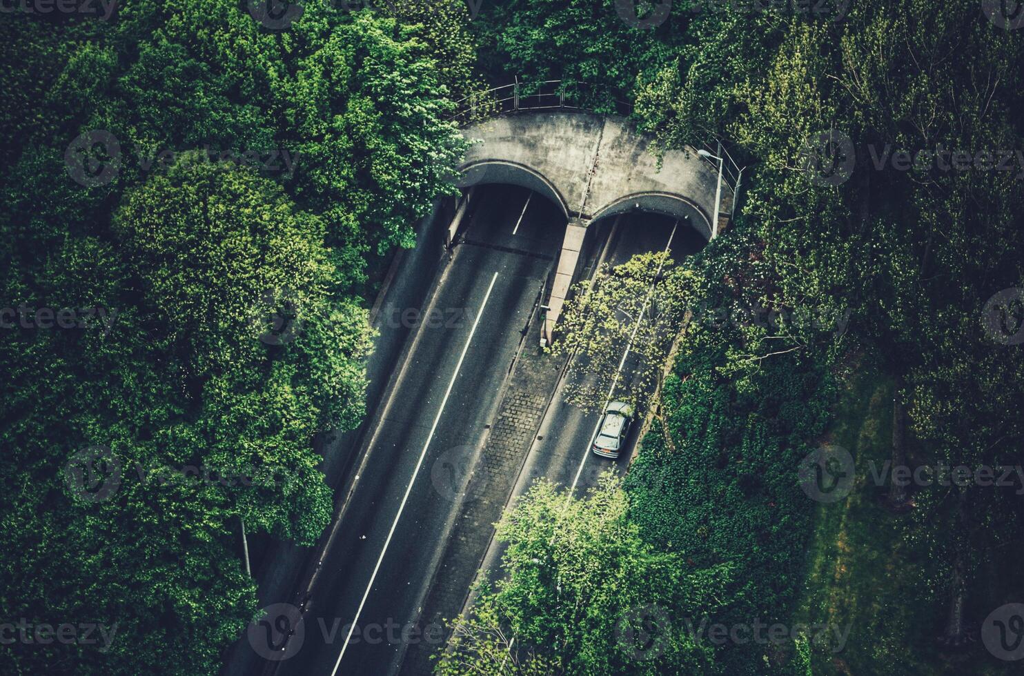 Drönare skott av motorväg tunnel i rotterdam omgiven förbi träd och skog foto