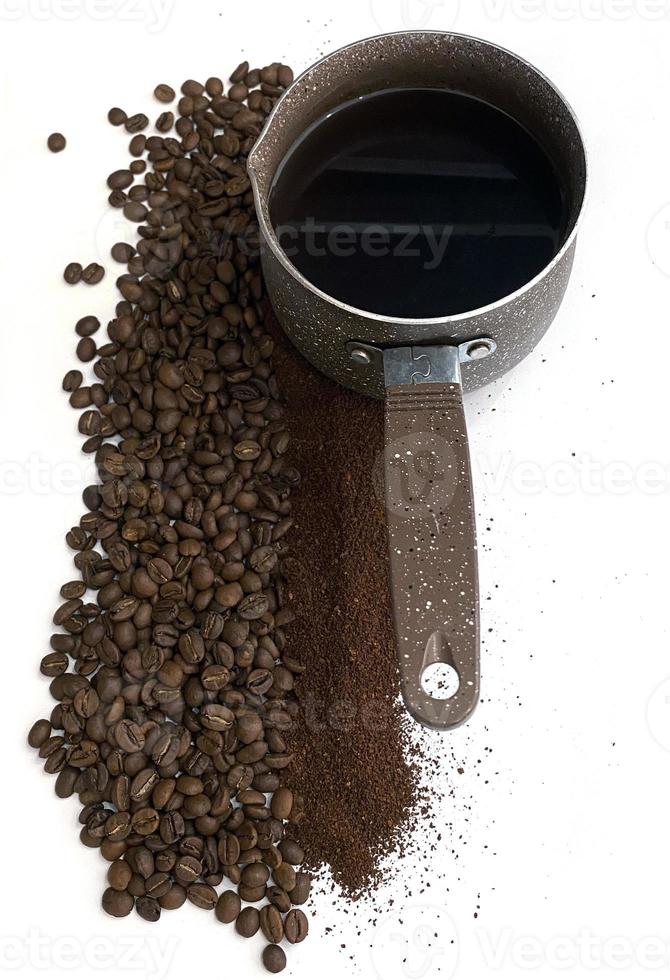 kaffe bönor, jord kaffe och kaffe cezve. de Foto visar kaffe bönor och jord kaffe. närliggande är kaffe cezve.