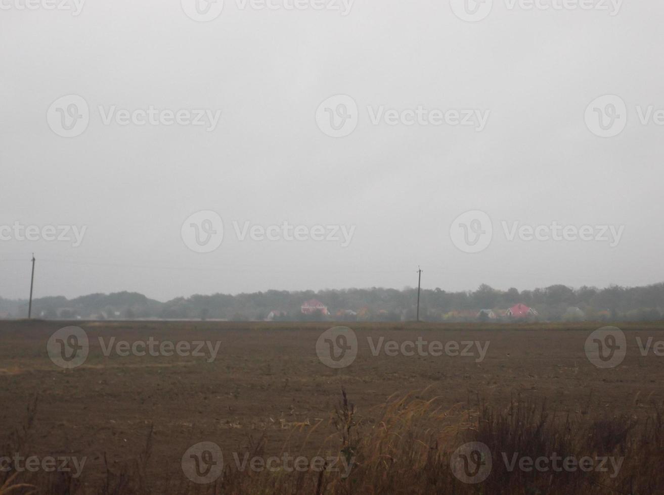 panorama av en plogade fält i de by på solnedgång foto