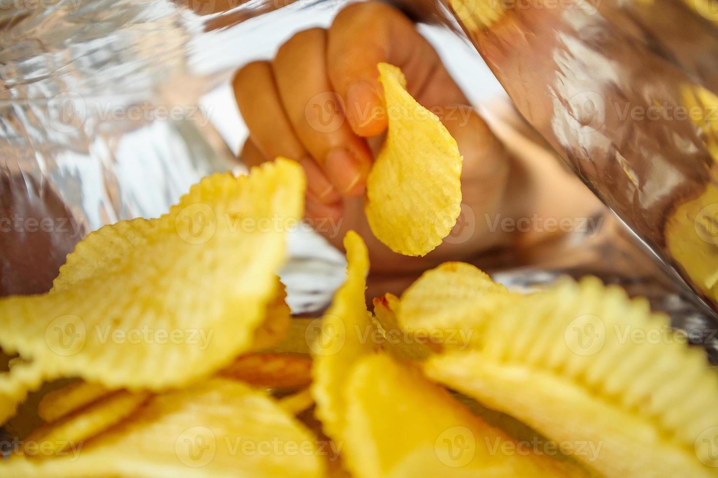 handhåll potatischips inuti snack foliepåse foto