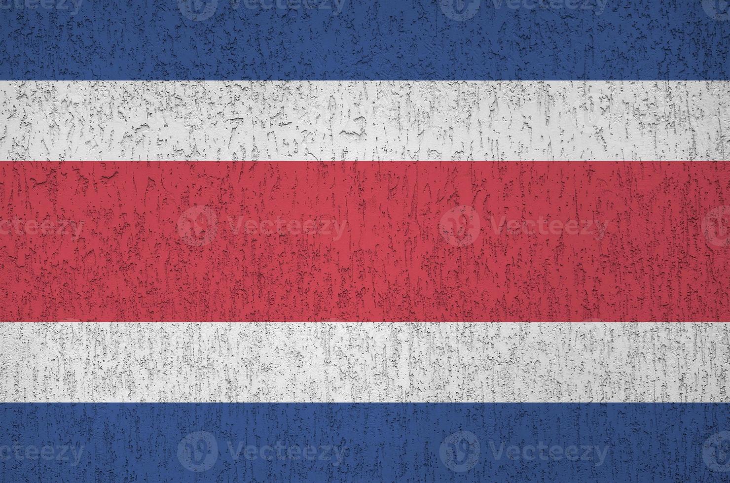 costa rica flagga avbildad i ljus måla färger på gammal lättnad putsning vägg. texturerad baner på grov bakgrund foto