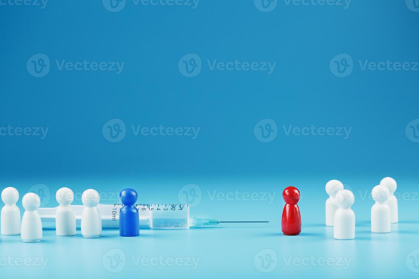 vaccinera eller vägra en spruta med en vaccin med två grupper av människor en röd och en blå mänsklig modell. foto