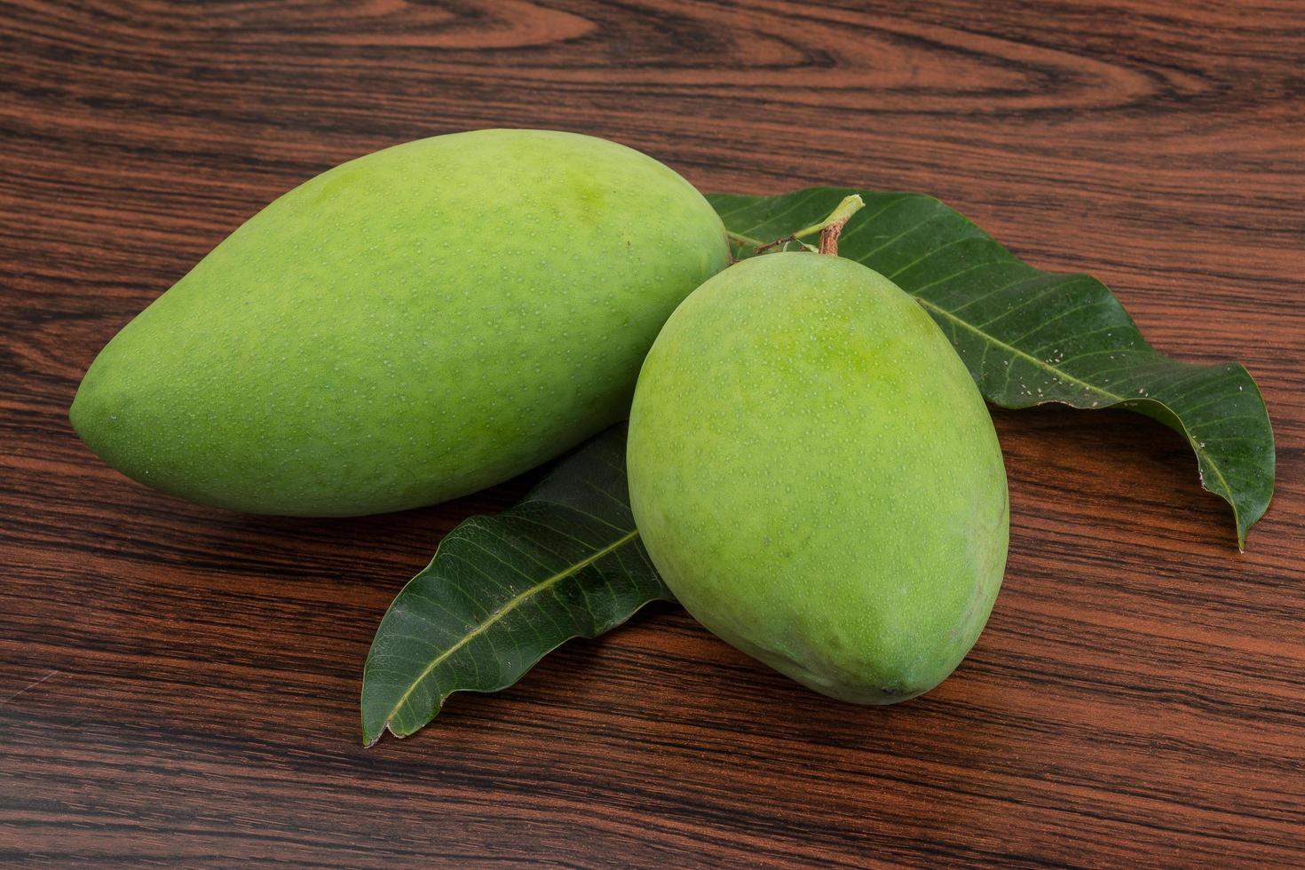 grön mango på trä foto