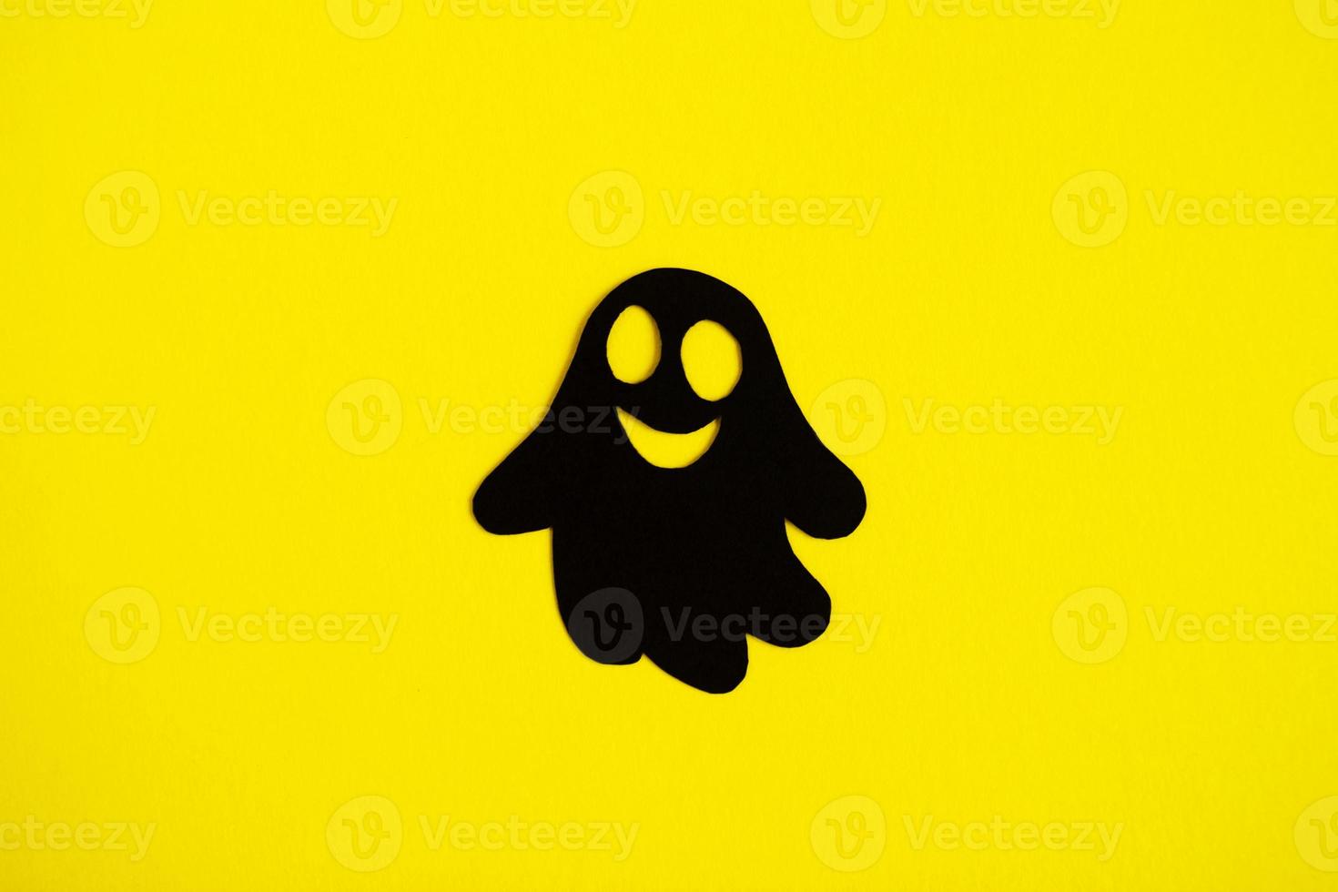 Semester dekorationer för halloween. svart papper spöke på en gul bakgrund, topp se. foto