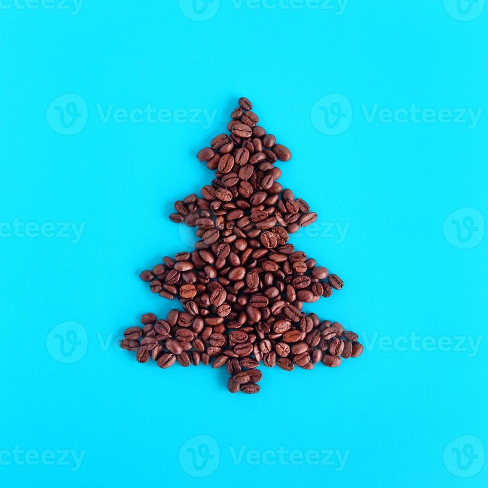jul träd tillverkad från kaffe bönor på en blå bakgrund, topp se. foto
