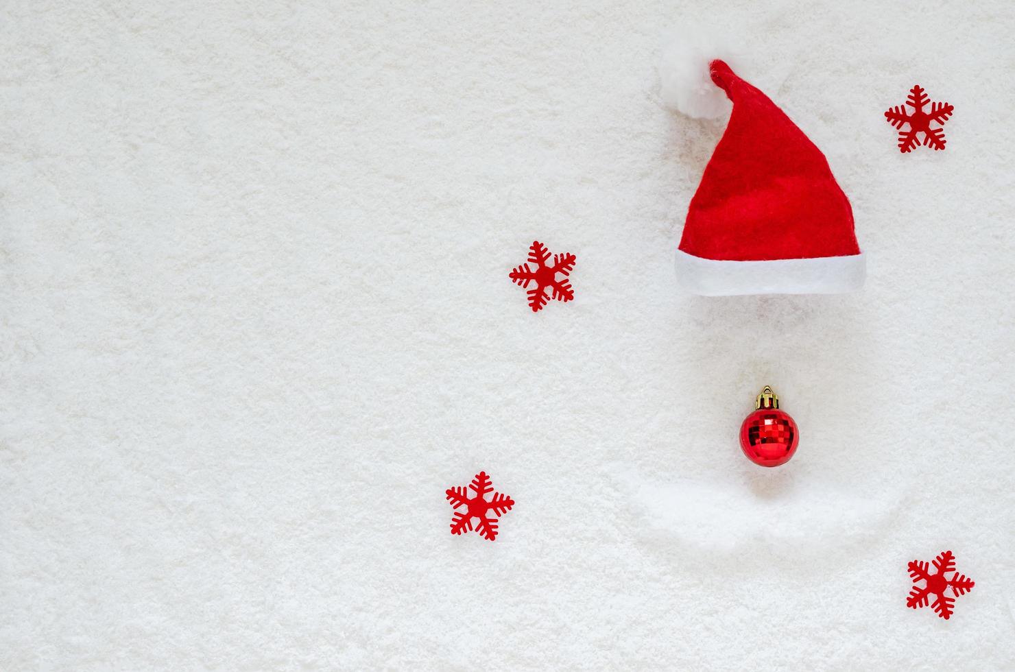 platt lägga av jul ornament och santa claus hatt sätta på snö bakgrund. foto