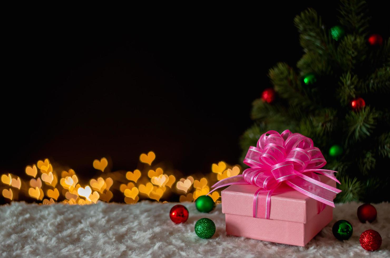 gåva låda och ornament med jul träd och kärlek form bokeh lampor bakgrund. jul och ny år begrepp. foto