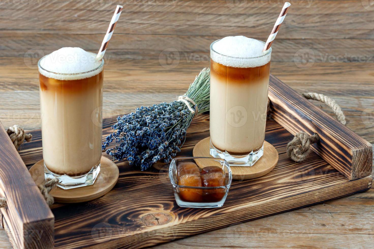 kaffe kopp av latte med hemlagad lavendel- sirap och blommor på en trä- bricka. mysigt frukost. foto