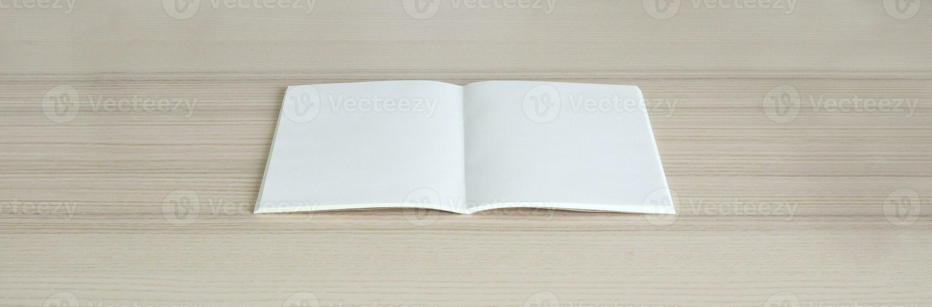 falsk upp tom öppen papper bok på trä tabell bakgrund foto