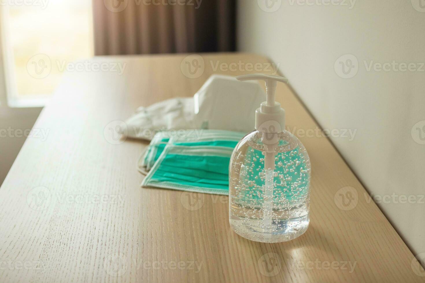 medicinsk ansikte mask med alkohol desinfektionsmedel gel hand tvätta på trä tabell för covid-19 coronavirus förebyggande begrepp foto