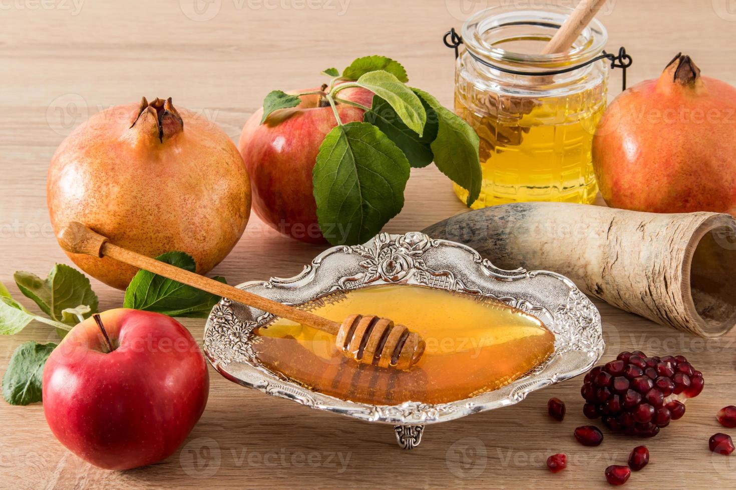 de jewish religiös Semester av roshashana. en sammansättning av traditionell behandlar . honung i en silver- skål, äpplen, granatäpple och dess korn. foto