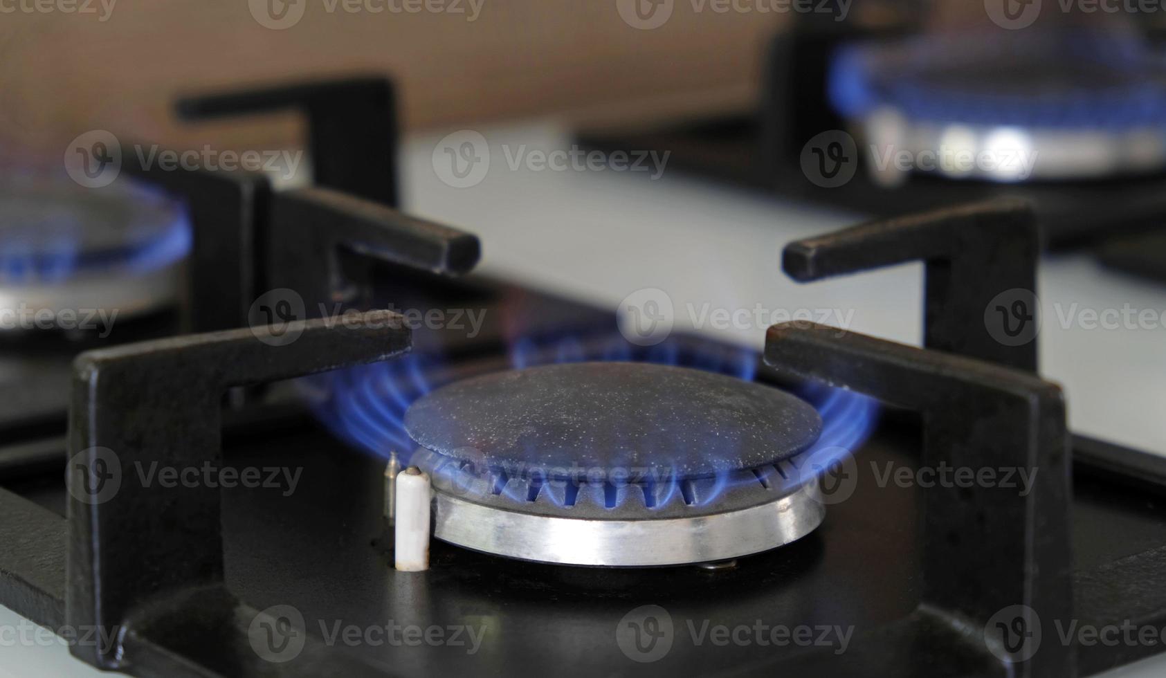 närbild blå lågor av brand på en gas brännare i de kök för matlagning. gas flamma i en gas panna foto