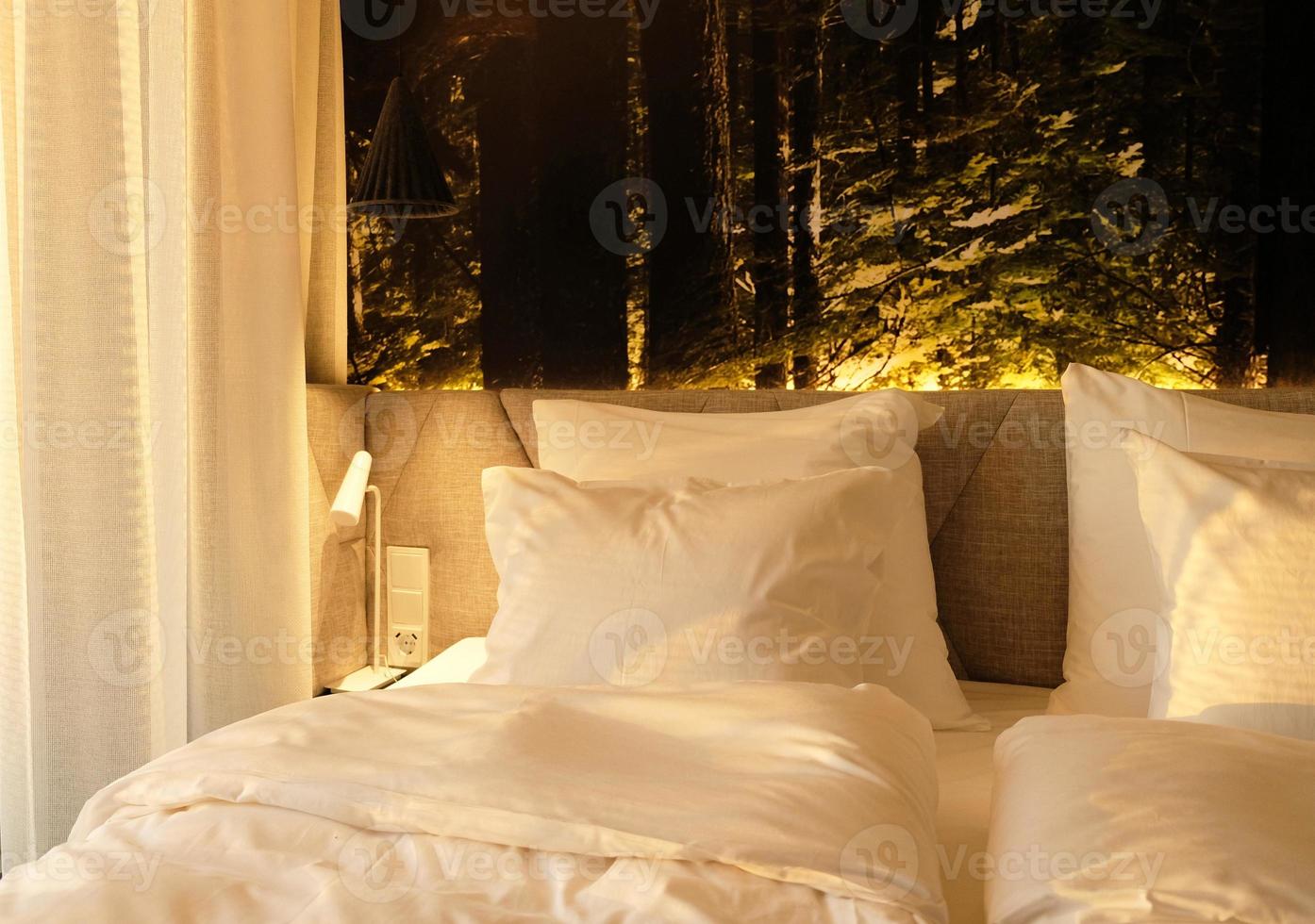 en fragment av en sovrum med en modern mysigt interiör design av en hus eller hotell. mjuk kudde och filt, eleganta bekväm möbel. foto