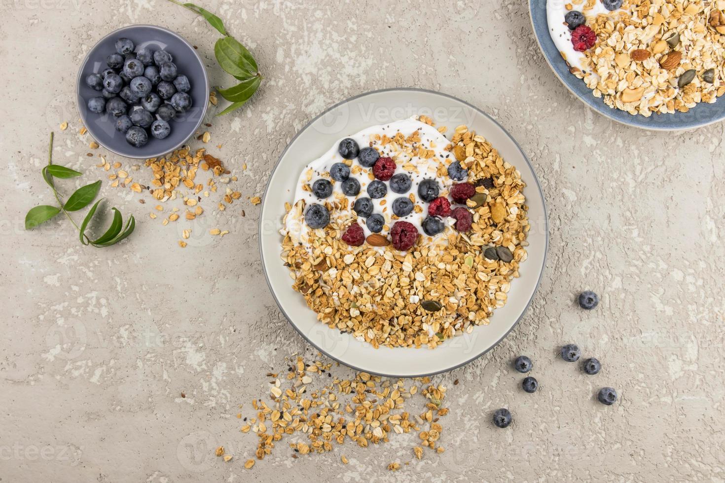 friska frukost med hemlagad granola och färsk organisk bär. topp se. grå bakgrund. de begrepp av rätt näring. foto