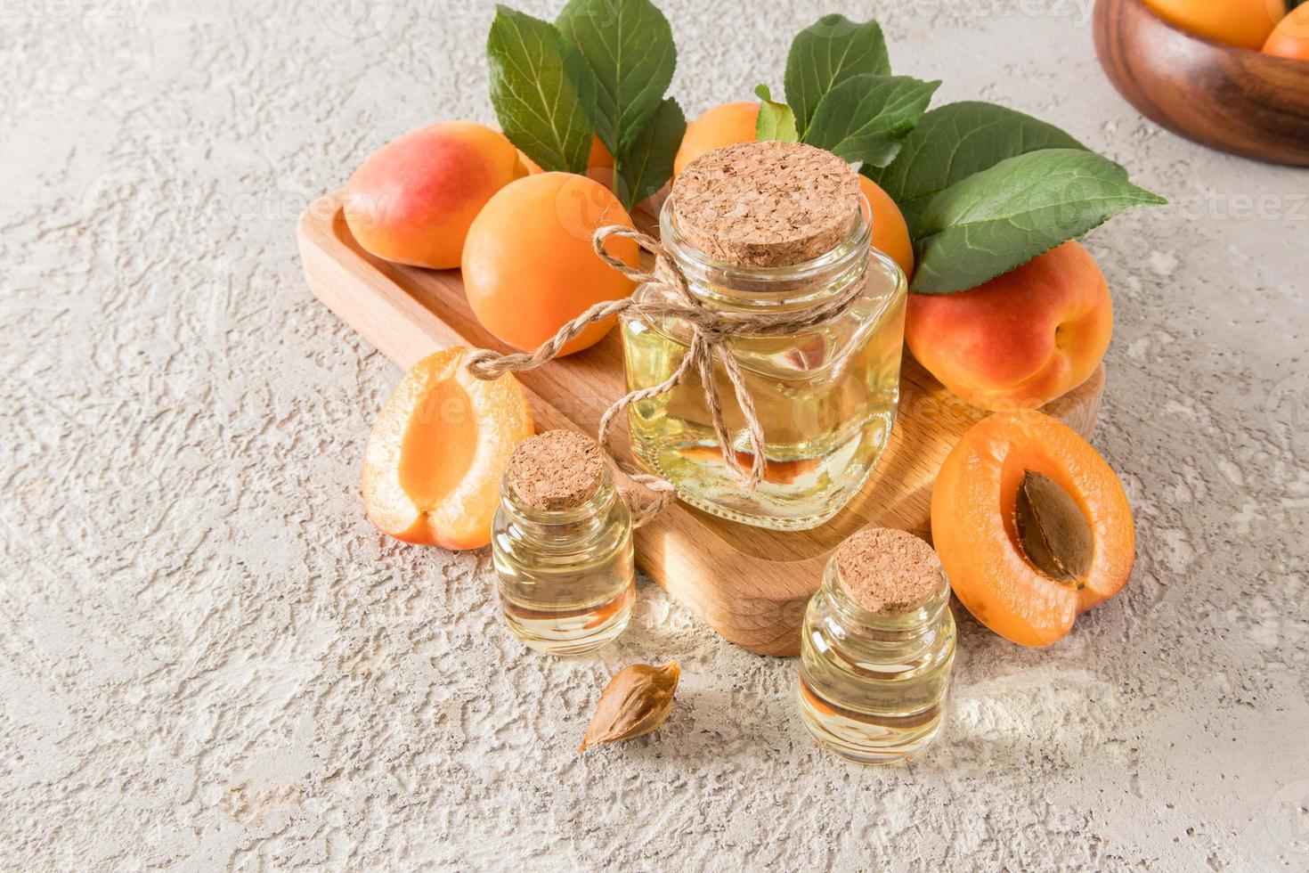 organisk naturlig aprikos kärna olja i olika bubblor på en trä- bricka bland mogen frukter. de begrepp av naturlig oljor och egenvård. foto