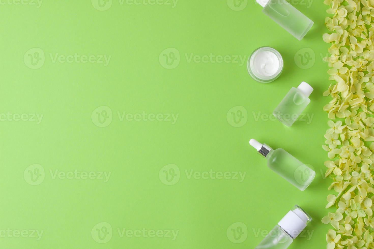 kosmetisk hud vård Produkter med blommor på grön bakgrund. platt lägga, kopia Plats foto