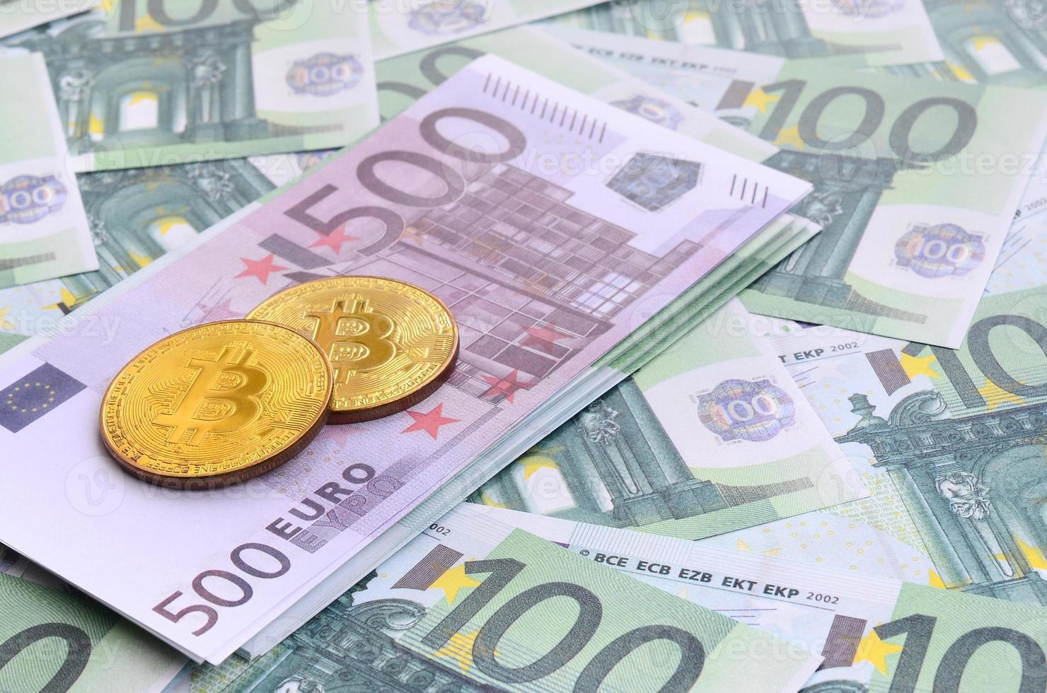gyllene fysisk bitcoins är lögner på en uppsättning av grön monetär valörer av 100 euro. en massa av pengar former ett oändlig högen foto