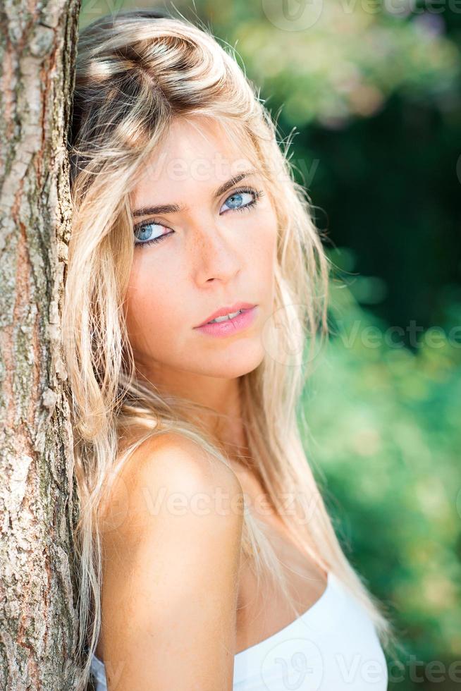 porträtt av skön blond flicka med blå ögon i natur foto