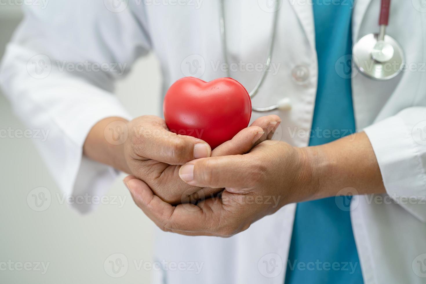 läkare som håller ett rött hjärta på sjukhusavdelningen, friskt starkt medicinskt koncept. foto