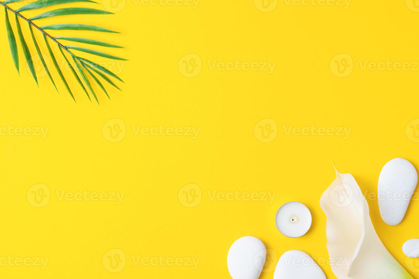spa bakgrund med vit stenar, ljus, handflatan blad och vit blomma på gul. platt lägga, kopiera Plats foto
