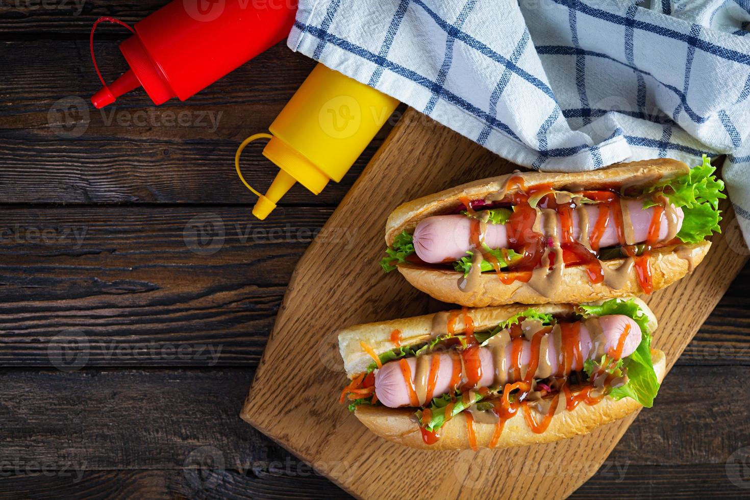 utsökt varm hund med ketchup och senap på trä- bakgrund. gata mat foto