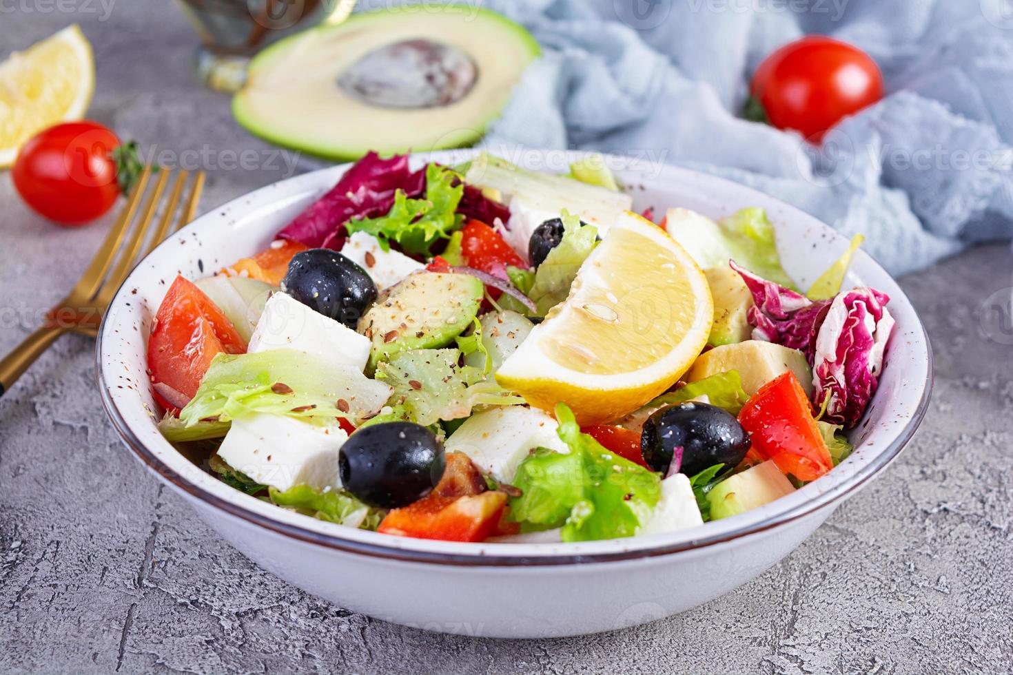 färsk sallad med tomat, sallad, avokado, oliver, fetaost och peppar. diet äter foto