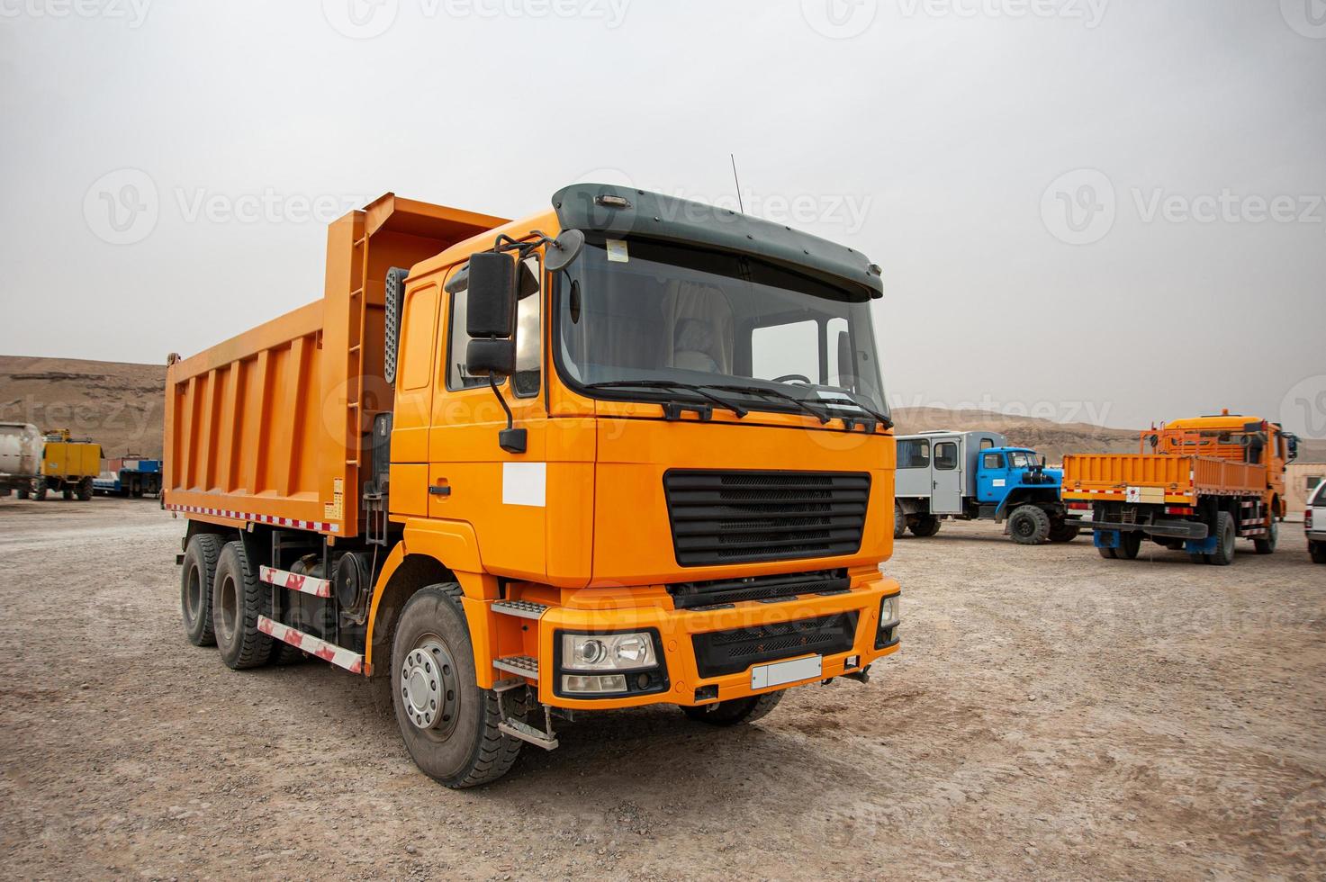 en närbild av ett orange dumper lastbil i ett konstruktion område foto