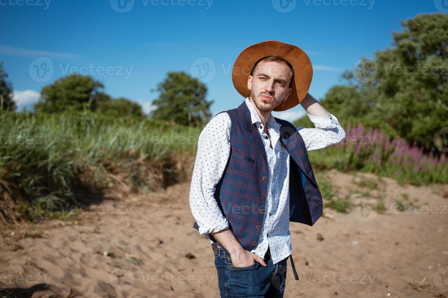 ung man i en hatt på natur utseende till de sida foto