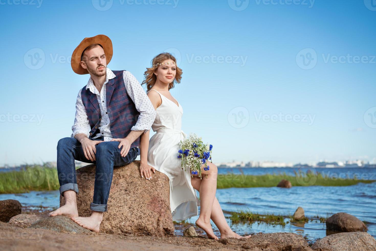 Lycklig par på de strand med en bukett av blommor foto