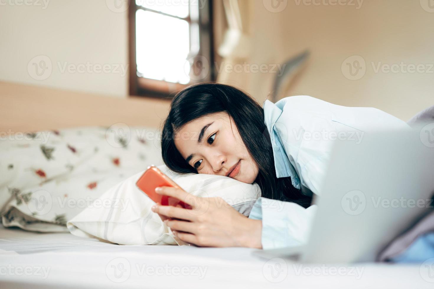 ung vuxen enda kvinna använder sig av smartphone i de moring för social meddelande app chatt med vän foto
