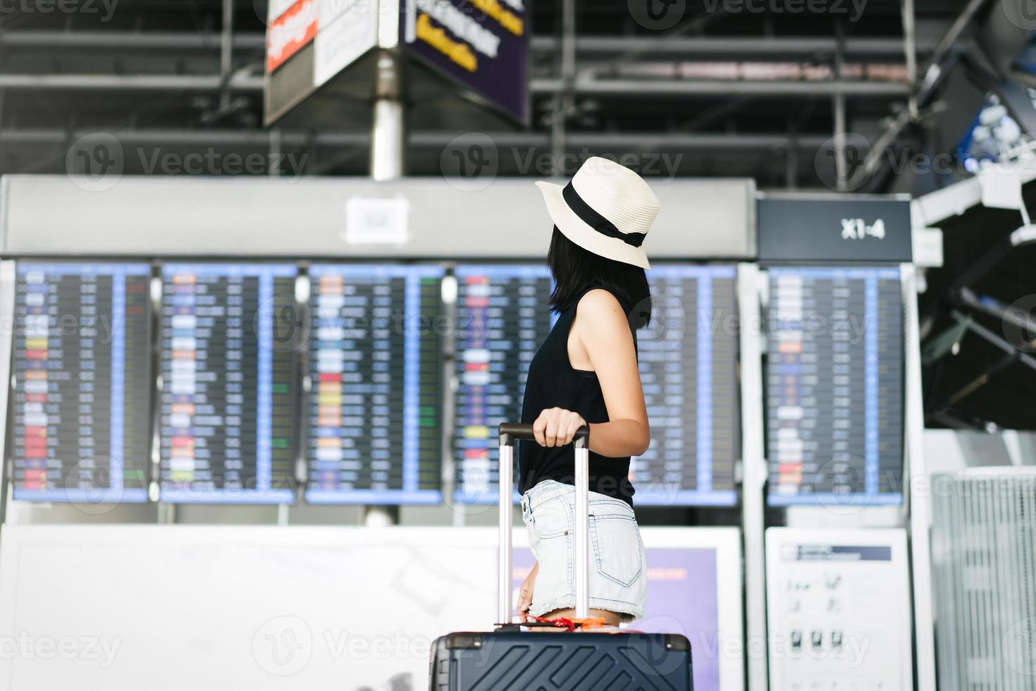 asiatisk vuxen turist kvinna med resa bagage i flygplats terminal på dag foto