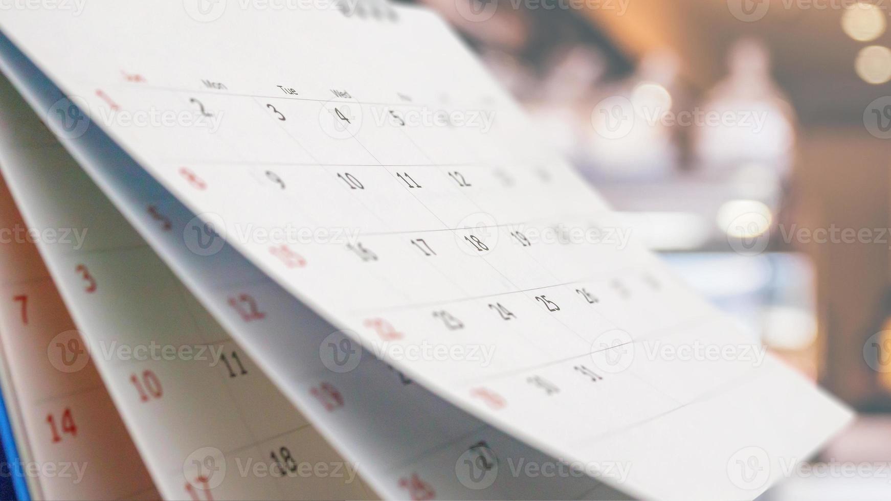 stänga upp vit papper skrivbord kalender med suddig bokeh bakgrund utnämning och företag möte begrepp foto