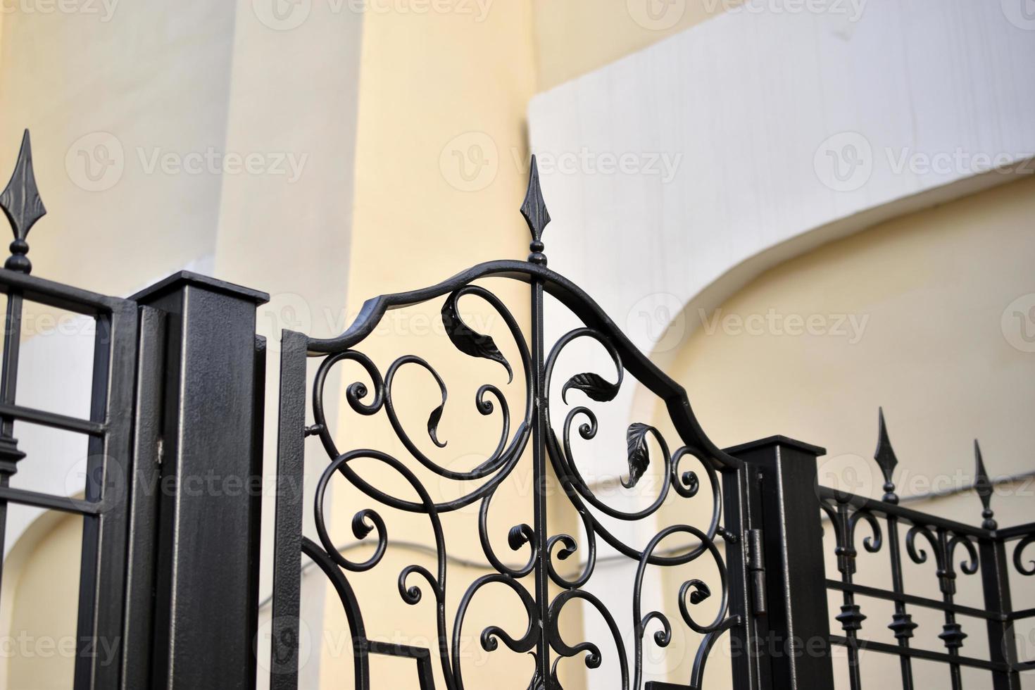 en klassisk gul hus och en skön järn staket med en Port. foto