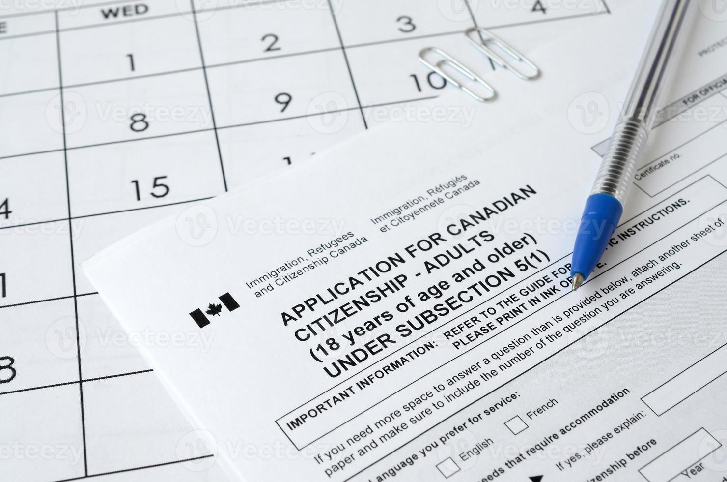 Ansökan för kanadensisk medborgarskap för vuxna och blå penna lögner på kalender sida foto