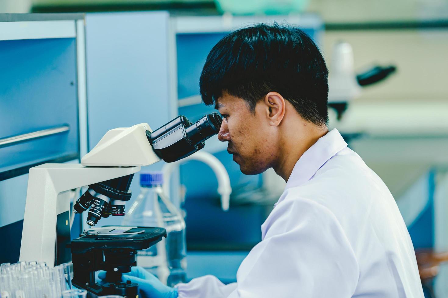 asiatisk manlig medicinsk eller vetenskaplig forskare eller läkare arbetssätt i de laboratorium.avancerat vetenskaplig labb för medicin, bioteknik, mikrobiologi utveckling foto