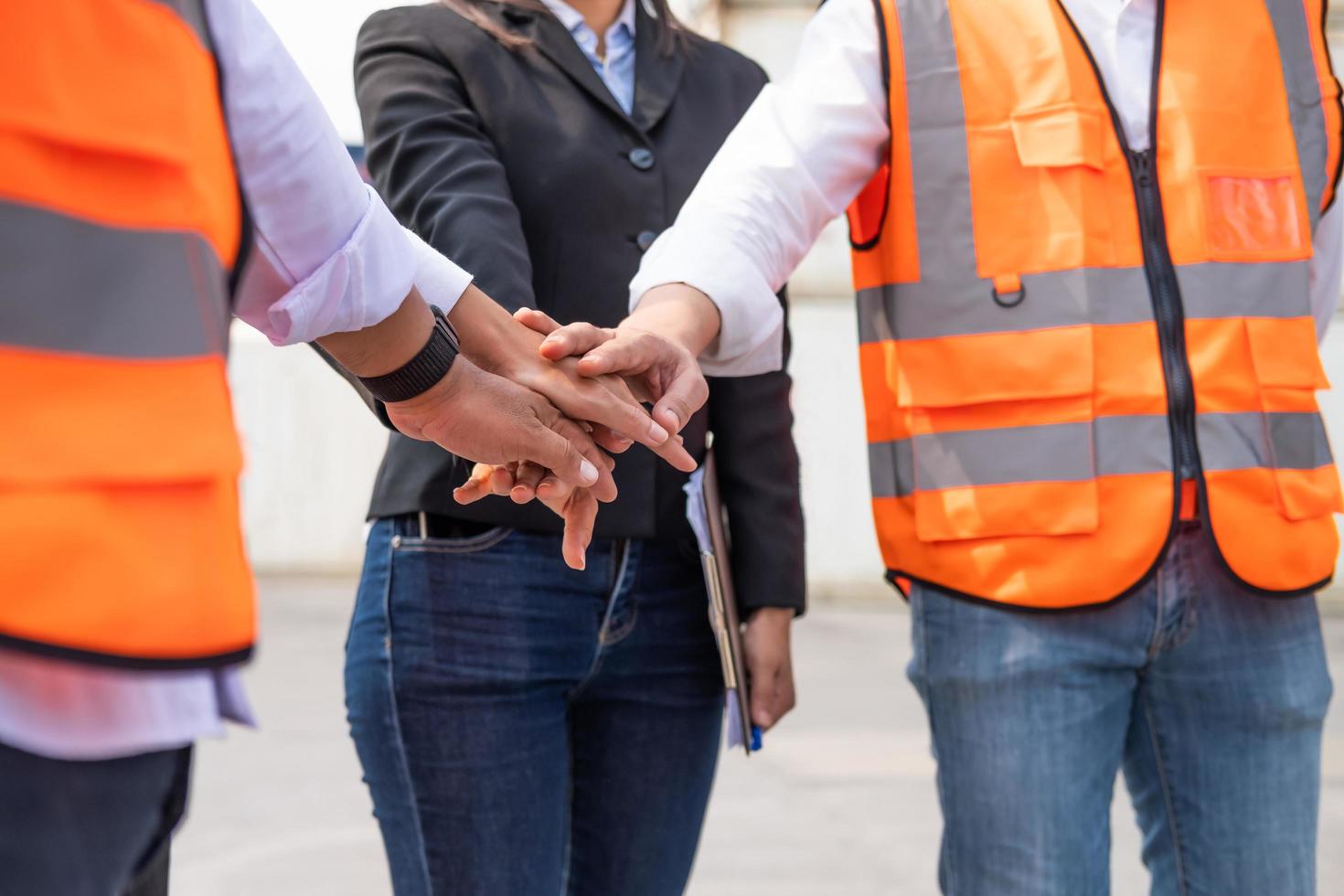 oidentifierad grupp av mång blanda lopp arbetstagare med handledare innehav hand till heja på upp och uppmuntra innan arbetssätt på industriell fabrik webbplats. lagarbete, arbetskraft spåna eller grupp arbetssätt begrepp. foto