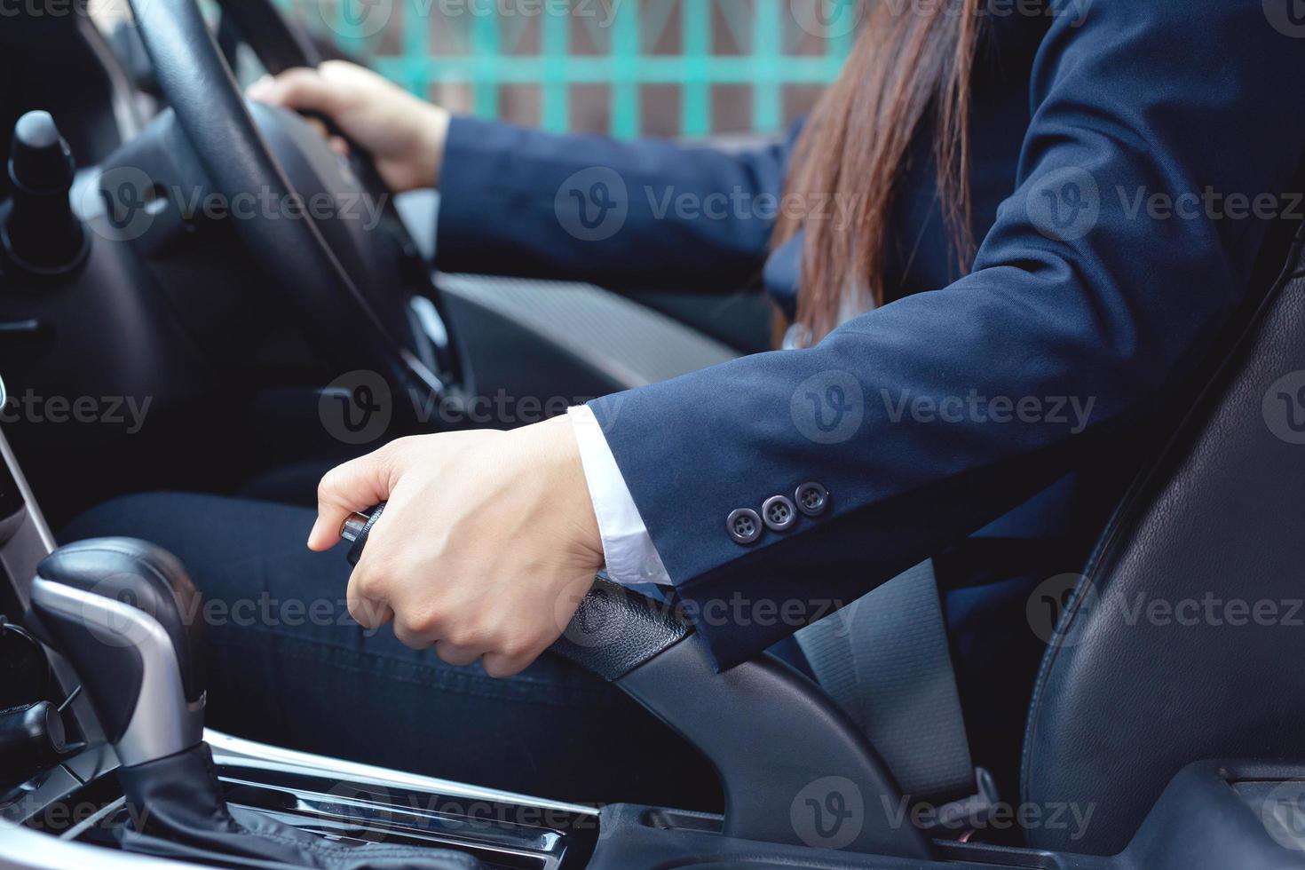 en kvinna parkering en bil med en hand broms för säkerhet foto