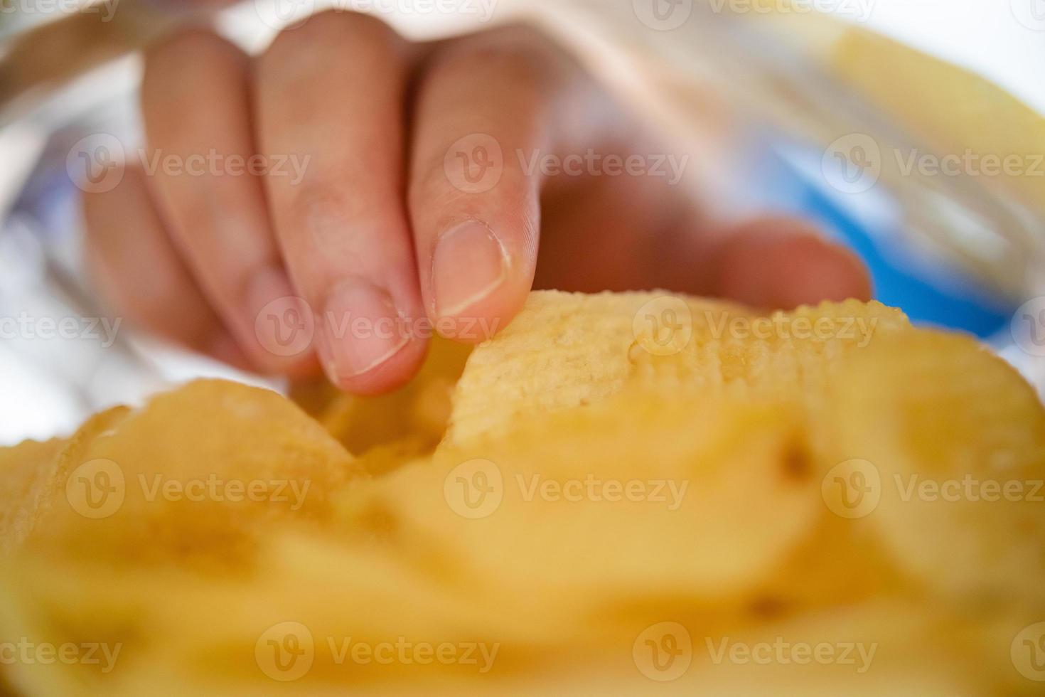hand plockning potatis pommes frites inuti mellanmål väska foto
