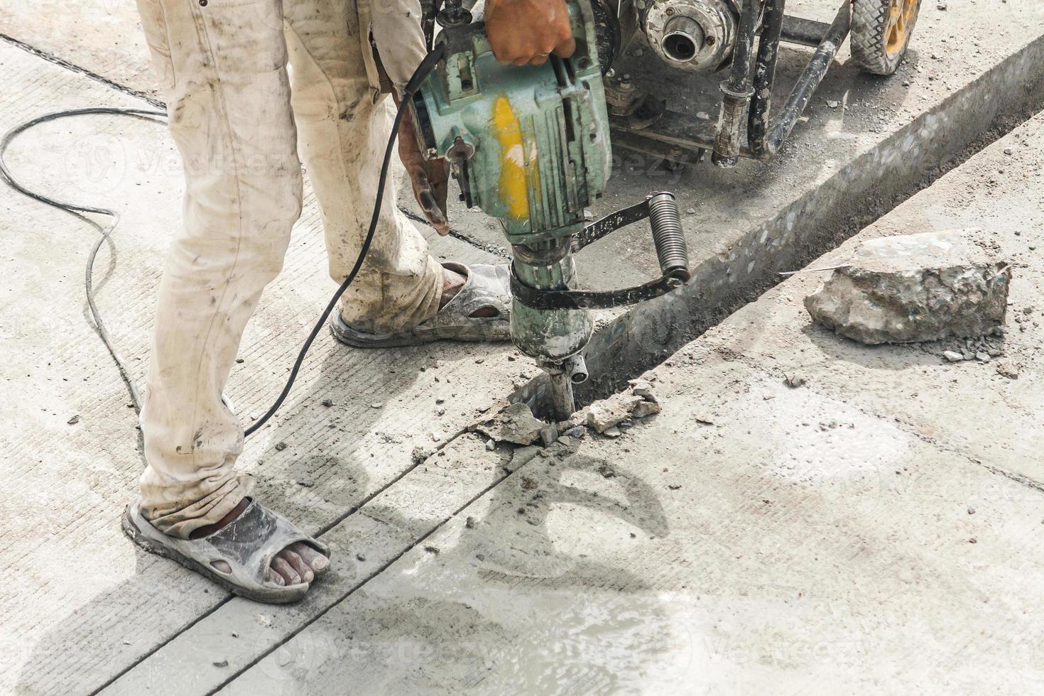 konstruktion arbetstagare använder sig av pneumatisk hammare borrning betong yta foto