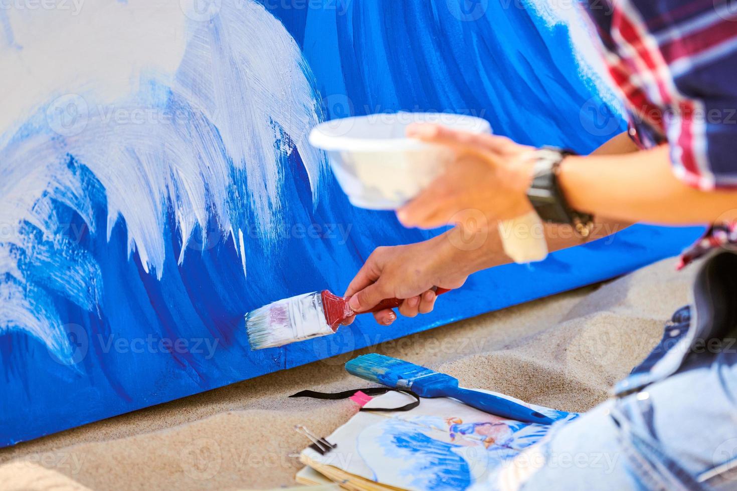 kvinna konstnär arbetssätt på abstrakt akryl målning, hand rör på sig måla borsta, stor duk utomhus- foto