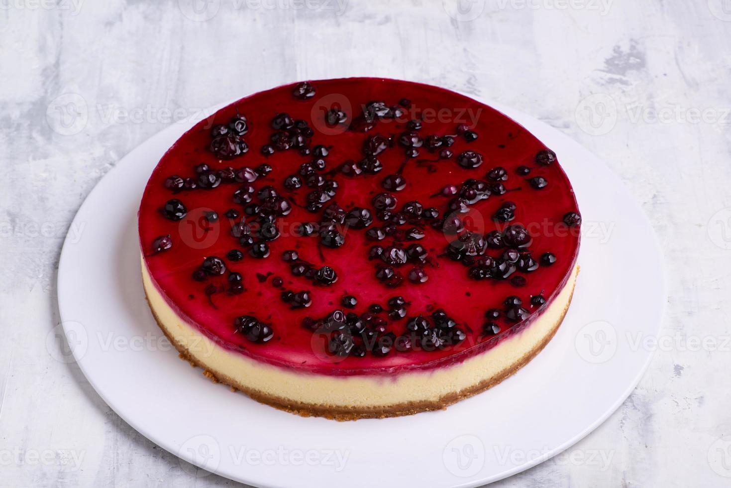 en cirkel av gott blåbär cheesecake på en vit tallrik på en vit marmor yta foto