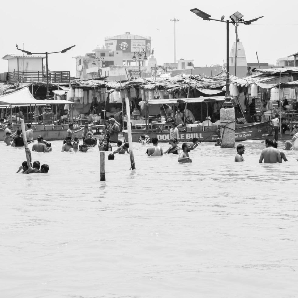 garh mukteshwar, up, Indien, 11 juni 2022 - människor tar ett heligt dopp med anledning av nirjala ekadashi, en utsikt över garh ganga brij ghat som är mycket känd religiös plats för hinduer-svart och vitt foto