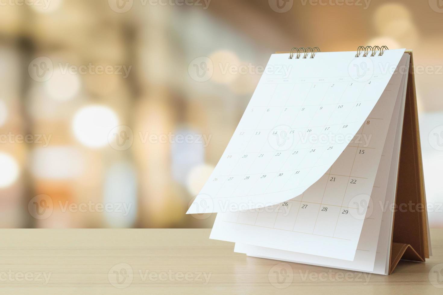 skrivbord kalender på tabell med suddig bokeh bakgrund utnämning och företag möte begrepp foto