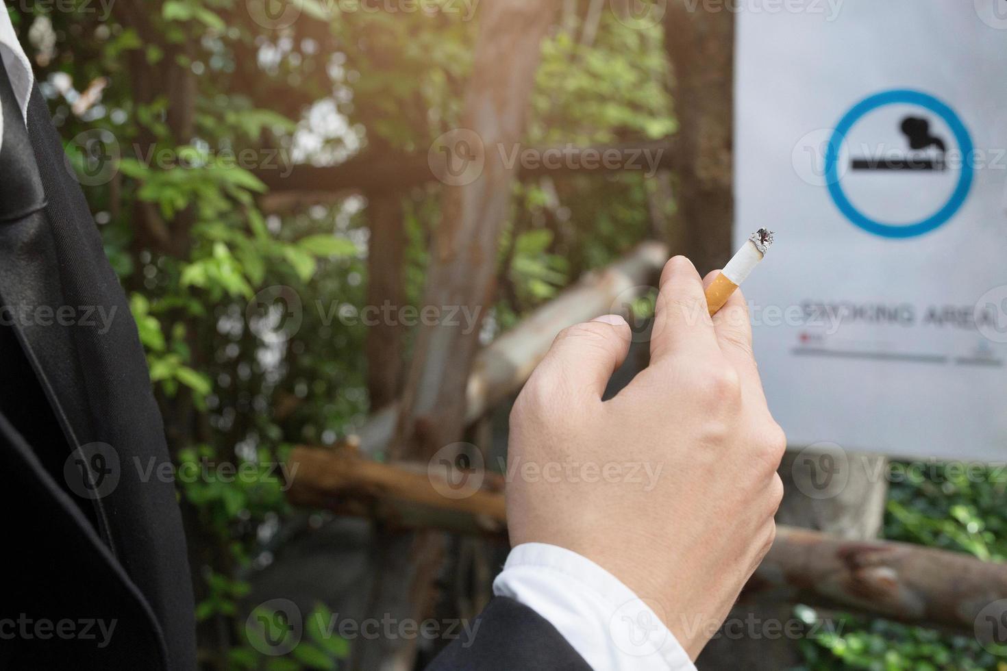 affärsmän cigaretter för rökning sitta i de parkera i de rökning zon område. foto